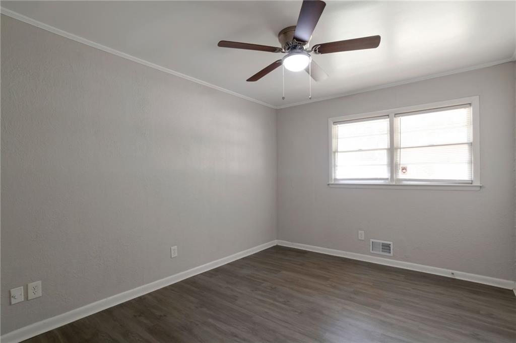 904 Pine Roc Drive Stone Mountain, GA 30083 - Photo 10 of 15 an empty room with wooden floor fan and windows