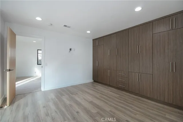 wooden floor in an empty room with a bathroom