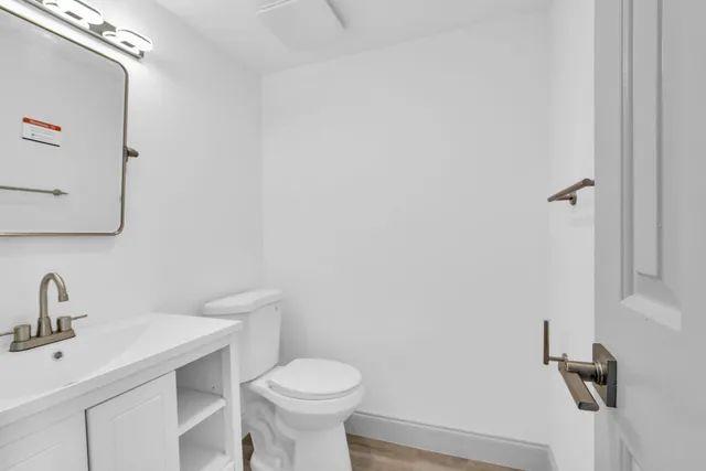 a bathroom with a sink mirror and toilet
