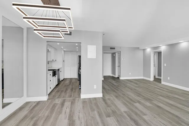 a view of empty room with wooden floor