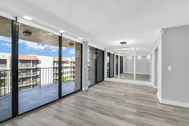 a view of an empty room with glass door and windows