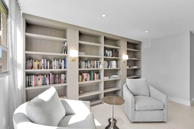 a living room with furniture a pool table and a large window