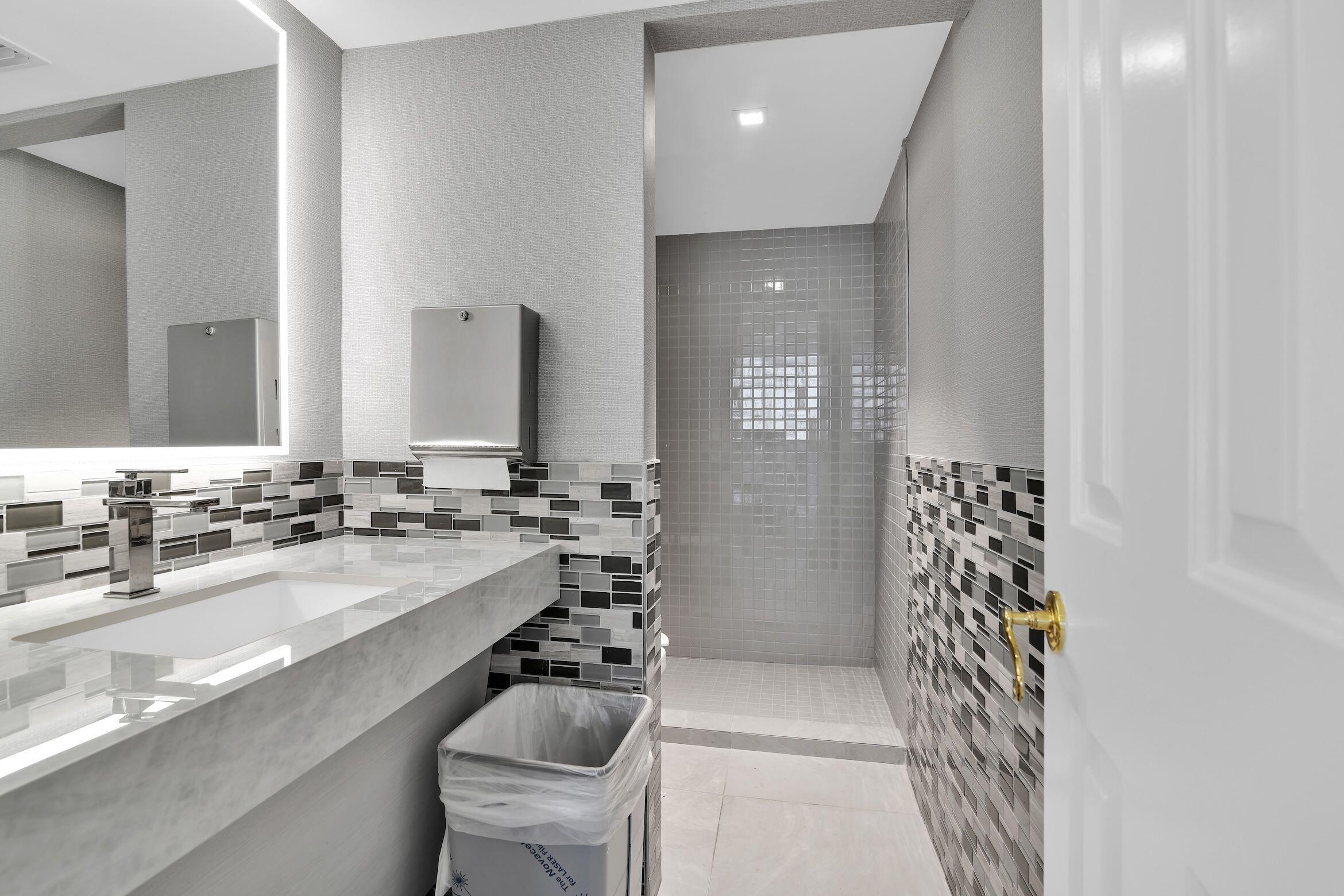 859 Jeffery Street, Unit 810 Boca Raton, FL 33487 - Photo 49 of 61 a bathroom with a sink a toilet a mirror and shower