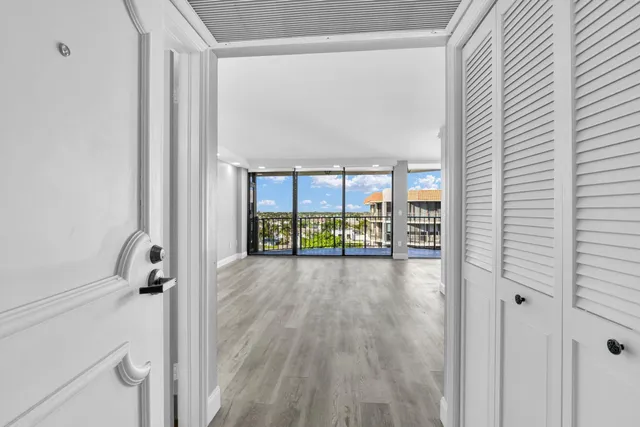 a view of a hallway with wooden floor and windows