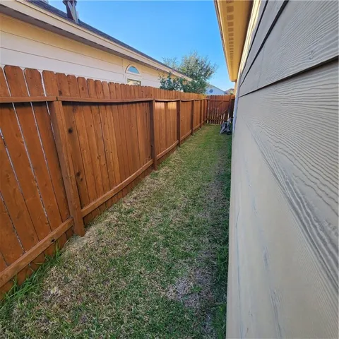 a view of a backyard with wooden fence