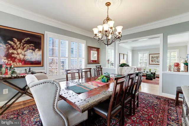 a view of a dining room with furniture a rug and wooden floor