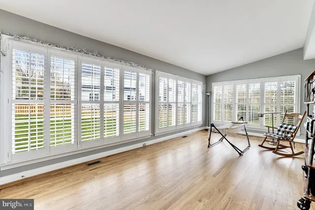 a view of a room with wooden floor and windows