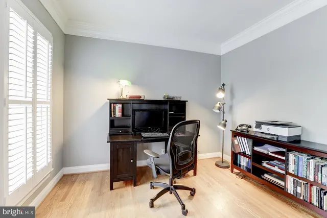 a view of a workspace with furniture and a window