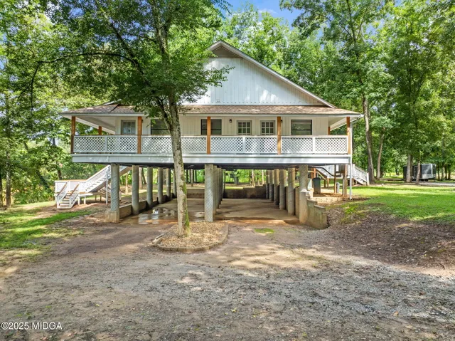 a view of a house with backyard and sitting area