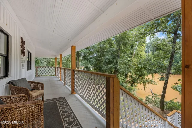 a balcony with wooden floor stairs and furniture