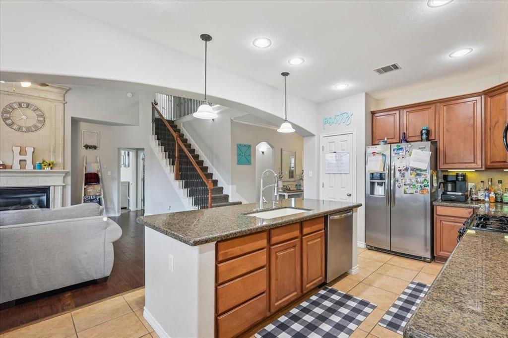 868 Valley Ridge Road Burleson, TX 76028 - Photo 10 of 39 a kitchen with stainless steel appliances kitchen island granite countertop a refrigerator a oven a sink and a center island