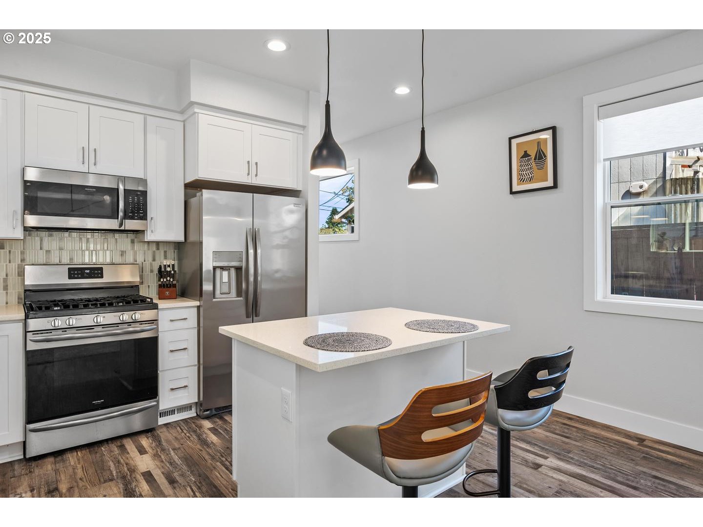 5424 Southeast Knapp Street Portland, OR 97206 - Photo 11 of 35 a kitchen with stainless steel appliances kitchen island granite countertop a stove a refrigerator a sink a dining table and chairs with wooden floor