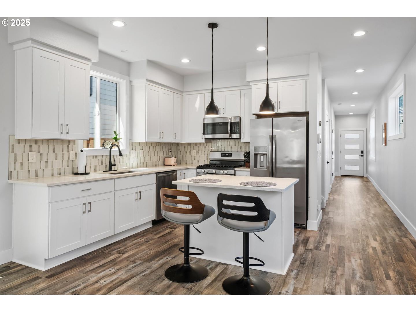 5424 Southeast Knapp Street Portland, OR 97206 - Photo 6 of 35 a kitchen with kitchen island granite countertop a sink a stove a refrigerator and white cabinets with wooden floor