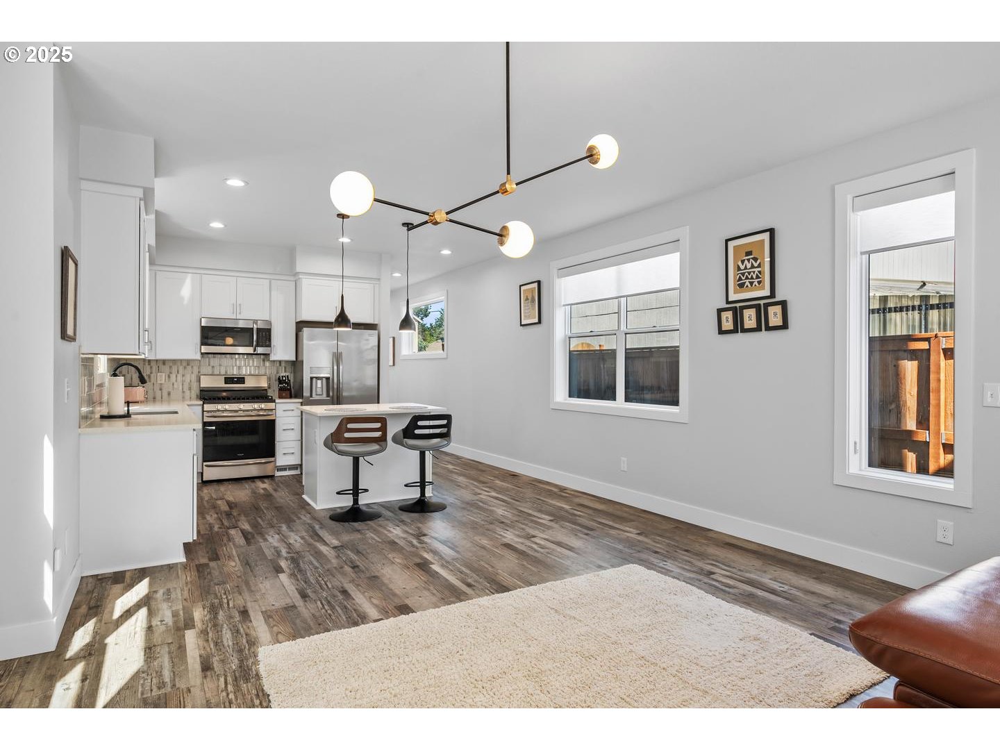 5424 Southeast Knapp Street Portland, OR 97206 - Photo 8 of 35 a kitchen with a refrigerator a stove top oven a sink dishwasher and white cabinets next to a window