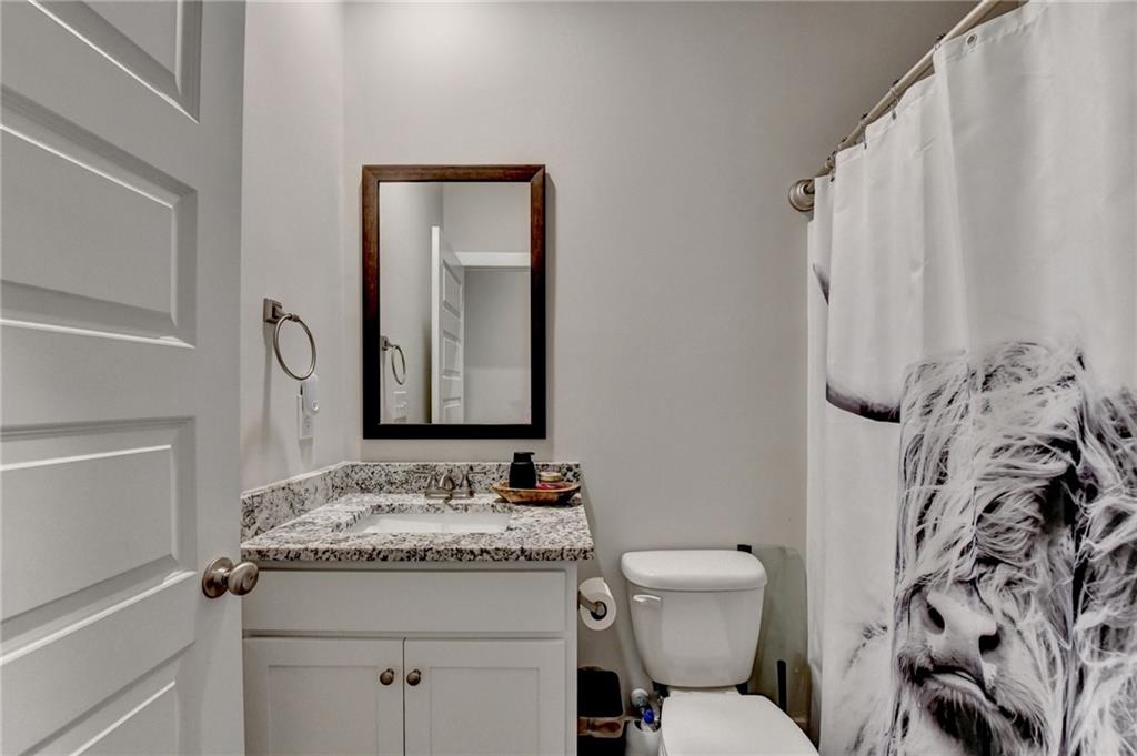 1179 Simmons Road Social Circle, GA 30025 - Photo 27 of 71 a bathroom with a granite countertop sink toilet and shower
