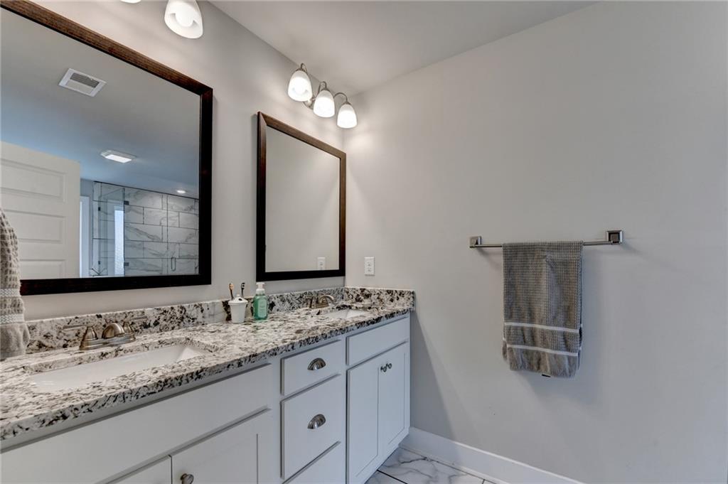 1179 Simmons Road Social Circle, GA 30025 - Photo 38 of 71 a bathroom with a granite countertop double vanity sink and a mirror