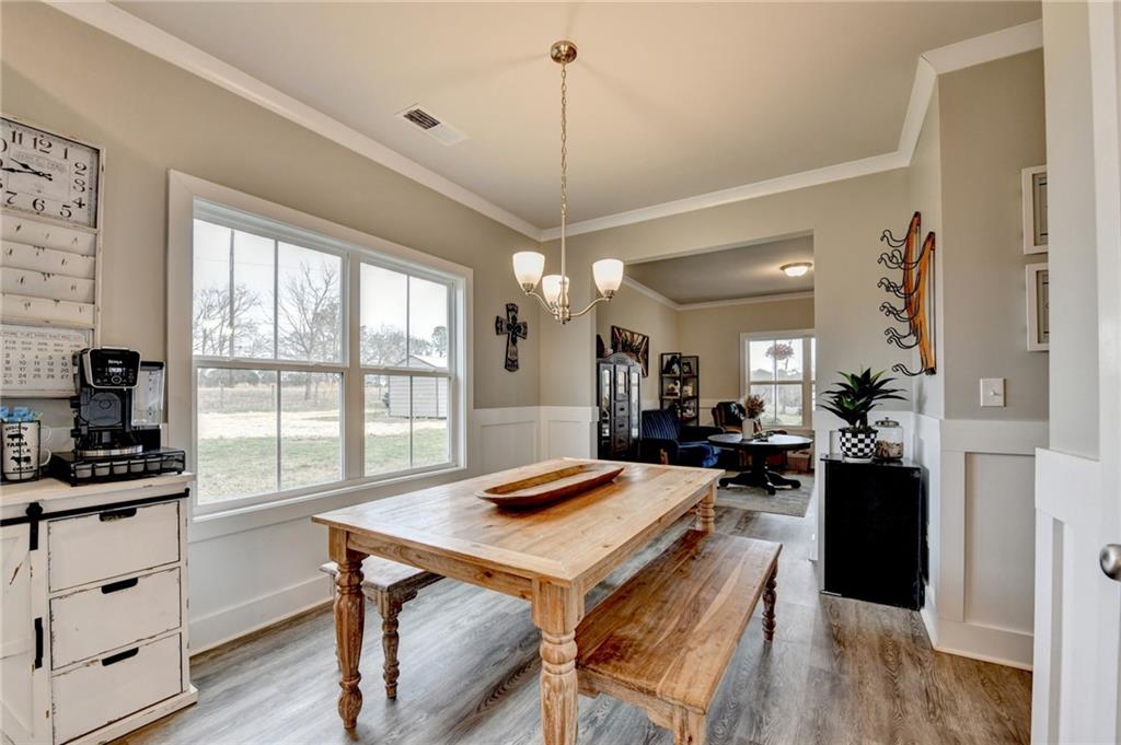 1179 Simmons Road Social Circle, GA 30025 - Photo 8 of 71 a view of a dining room and livingroom with furniture wooden floor a chandelier