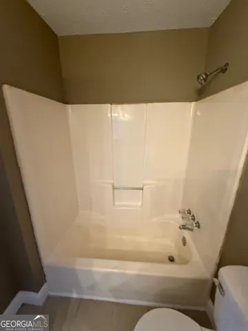 a bathroom with a granite countertop sink a toilet and a mirror