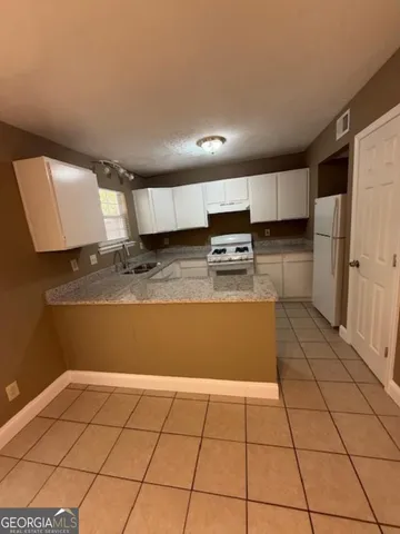 a kitchen with stainless steel appliances a refrigerator sink and cabinets
