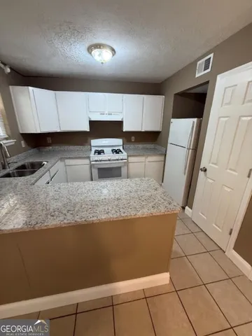 a kitchen with stainless steel appliances granite countertop a sink a stove a microwave a sink and cabinets