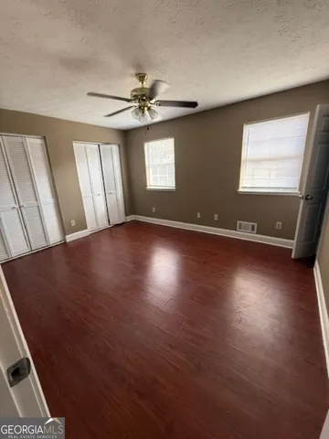 a view of a livingroom with wooden floor and stairs