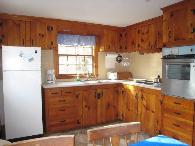 49 Captain Chase Road Dennis Port, MA 02639 - Photo 4 of 18 a kitchen with granite countertop a sink cabinets stainless steel appliances and a window