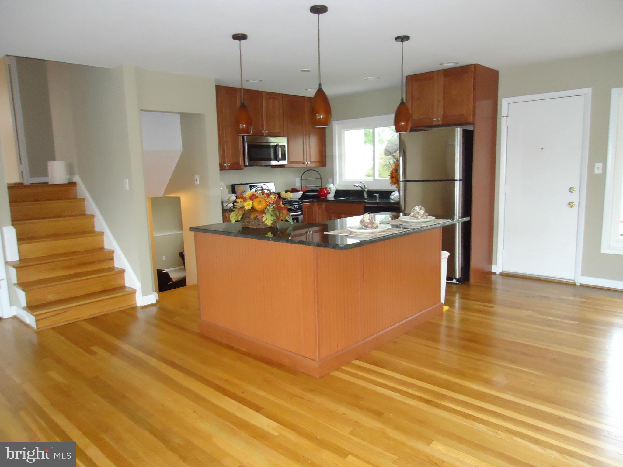 3614 Bellmore Road Baltimore, MD 21244 - Photo 5 of 20 a view of a kitchen with stainless steel appliances granite countertop a refrigerator a stove and a wooden floor