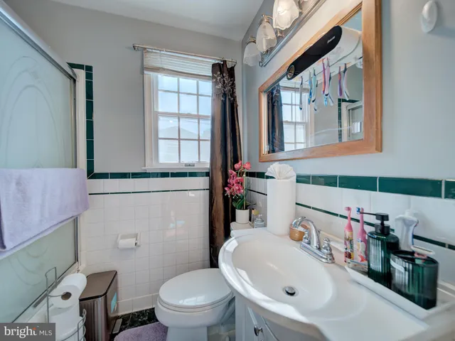 a bathroom with a sink a toilet and a mirror