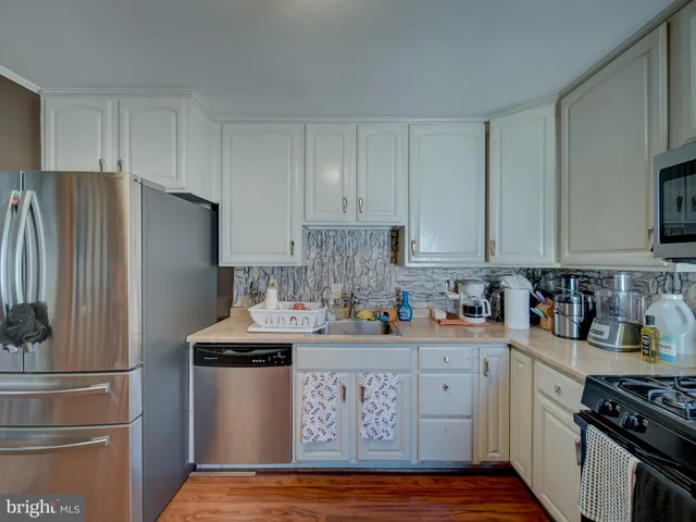 a kitchen with stainless steel appliances granite countertop a refrigerator stove and sink