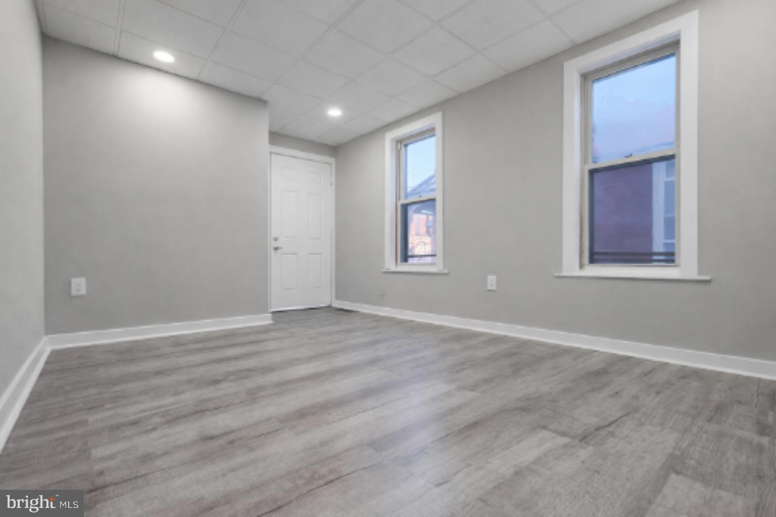 1013 North 10th Street Reading, PA 19604 - Photo 19 of 27 an empty room with wooden floor and windows