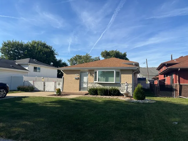 a front view of a house with a garden and yard