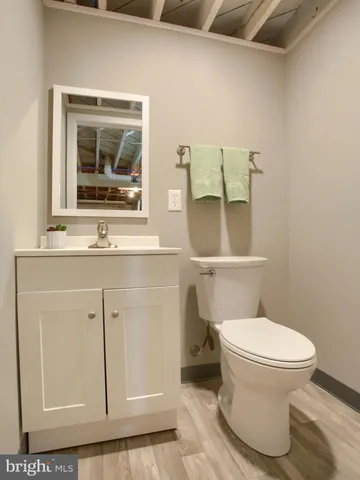 a bathroom with a toilet sink vanity and mirror