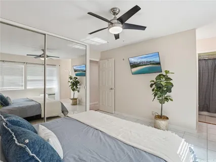 a bedroom with a large bed and a chandelier