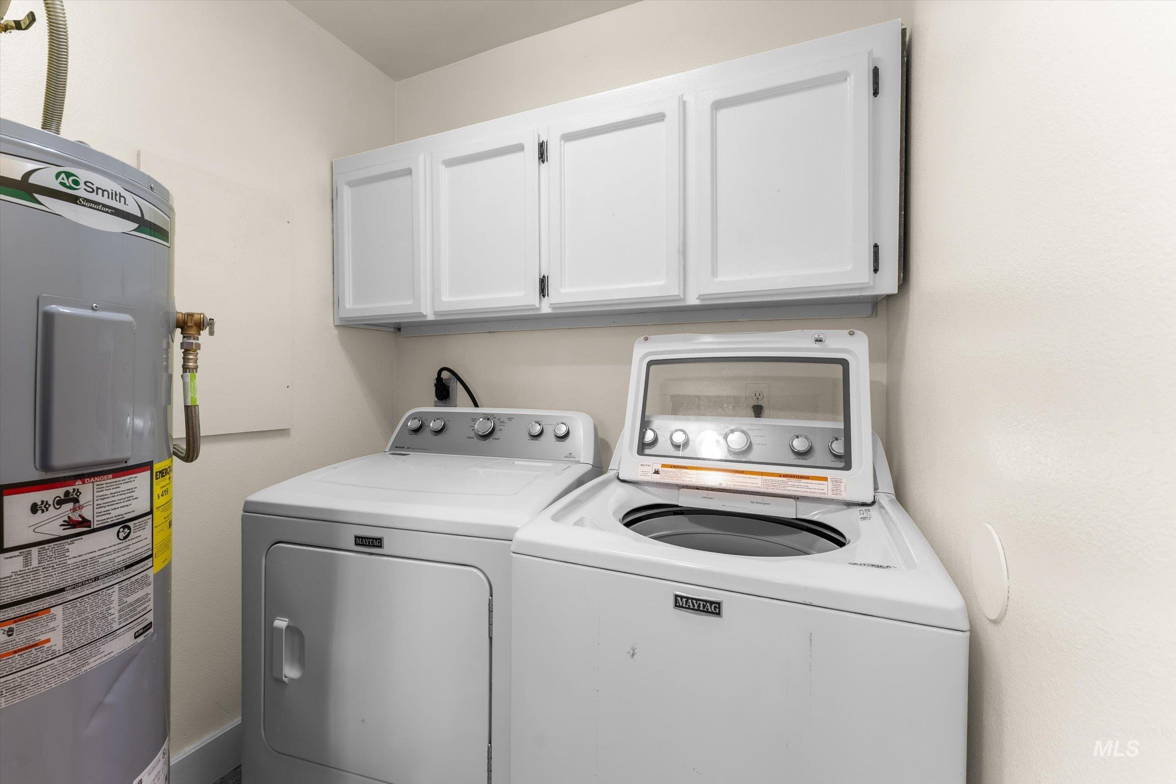 315 South Middlefork Road Garden Valley, ID 83622 - Photo 27 of 49 Laundry area featuring electric water heater, cabinet space, and washing machine and clothes dryer