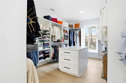 a view of walk in closet with clothes and shoes