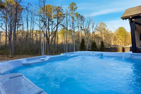 a kitchen with stainless steel appliances kitchen island granite countertop a refrigerator a stove a sink a dining table and chairs with wooden floor