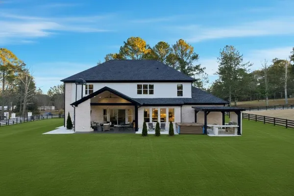 a large open kitchen with stainless steel appliances kitchen island a stove a refrigerator a dining table and chairs with wooden floor