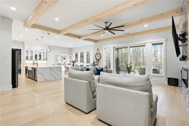 a living room with furniture a large window with kitchen view