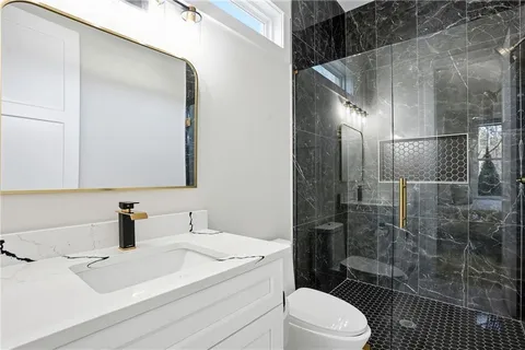 a bathroom with a sink a toilet and shower