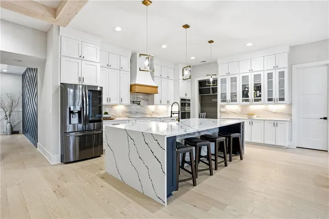a kitchen with kitchen island granite countertop wooden cabinets and refrigerator