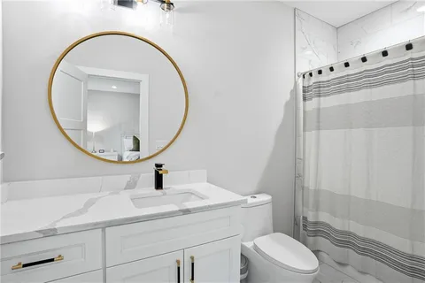 a bathroom with a sink a toilet and a mirror