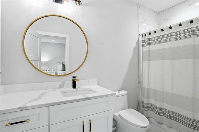 a bathroom with a sink a toilet and a mirror