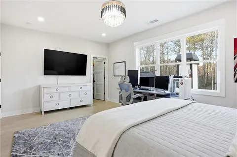 a bedroom with a bed a television and a large window