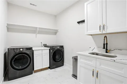 a utility room with sink dryer and washer