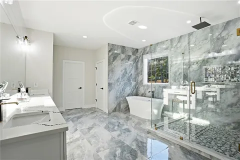 a spacious bathroom with a granite countertop sink a toilet a mirror and shower