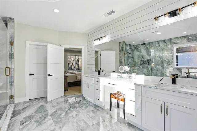 a bathroom with a sink vanity granite tub shower and view living room