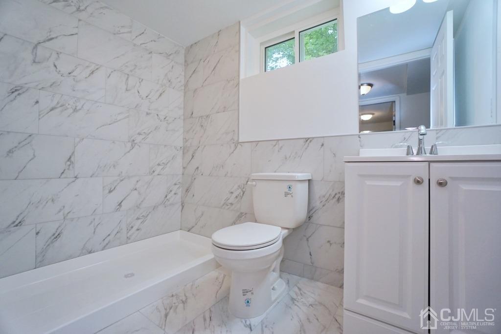 50 Dock Road Matawan, NJ 07747 - Photo 26 of 37 a bathroom with a granite countertop toilet a sink and a mirror