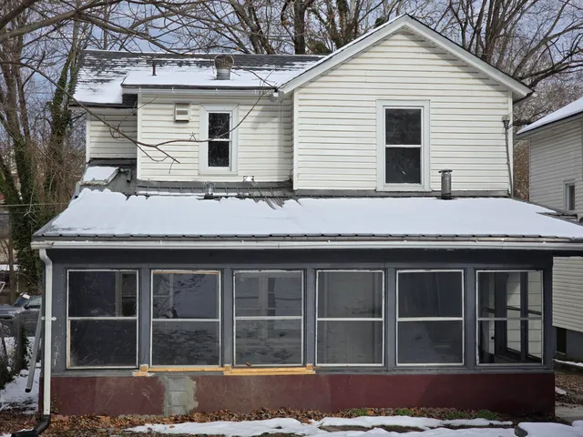 a backyard of a house with a yard covered with snow in front of house