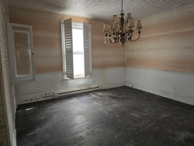 an empty room with windows and chandelier