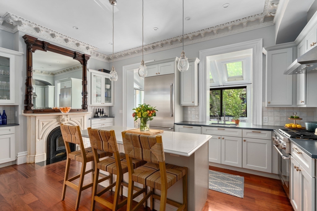 32 Rutland Square, Unit 1 Boston, MA 02118 - Photo 2 of 24 a kitchen with a table chairs refrigerator and microwave